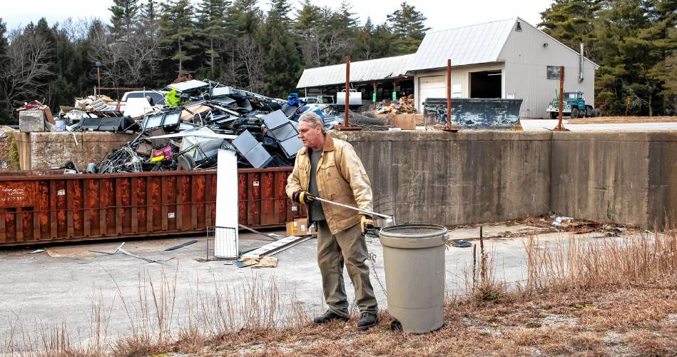 ABOVE: Hopkinton Webster Transfer Station employee Ted Valley picks up trash along the service road in front of the recycling center.