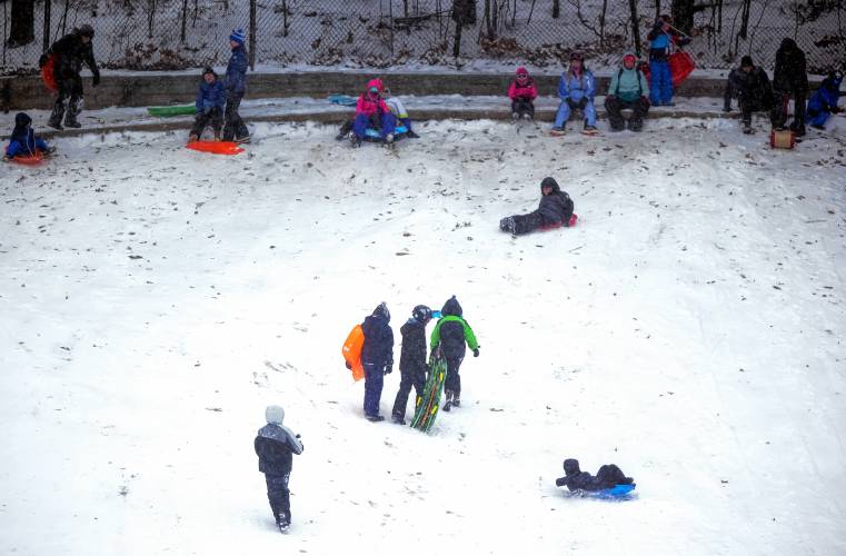 The snow hill at White Park was popular during the Sunday snowstorm for sledders and parents.