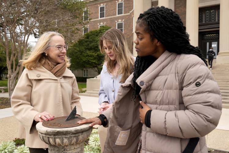 Alexis McCrossen, left, explains how a sun dial works to Hannah Spohn, center and Taylor Good, right, both freshman at Southern Methodist University in Dallas, Wednesday, Feb. 28, 2024. McCrossen, a history professor at SMU, has written books on marking time. (AP Photo/Tony Gutierrez)
