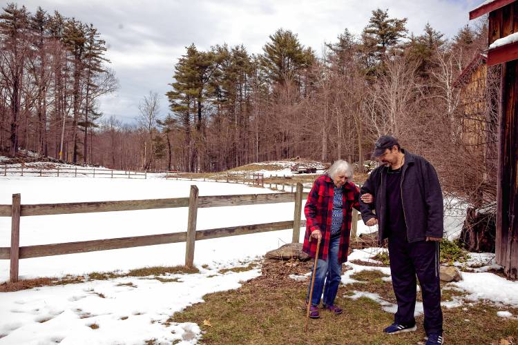 Roy Plisko walks with his mother, Virginia LaPlante outside his mother’s barn at her farm in Canterbury on Wednesday, March 27, 2024. New Hampshire Horse Council’s Board of Directors named LaPlante New Hampshire's 2024 Horse Person of the Year.