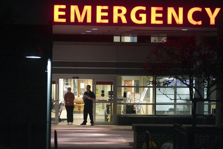 A member of security, center right, stands at an emergency department entrance at Central Maine Medical Center during an active shooter situation, in Lewiston, Maine, Wednesday, Oct. 25, 2023. (AP Photo/Steven Senne)