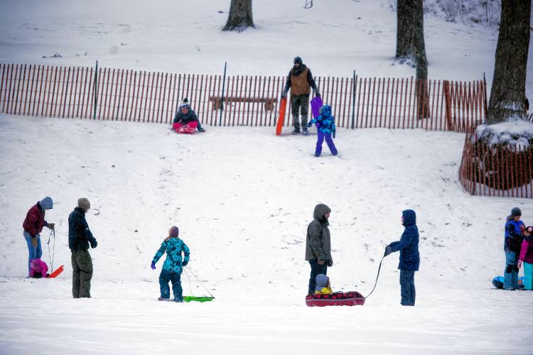 The snow hill at White Park was popular during the Sunday snowstorm for sledders and parents.