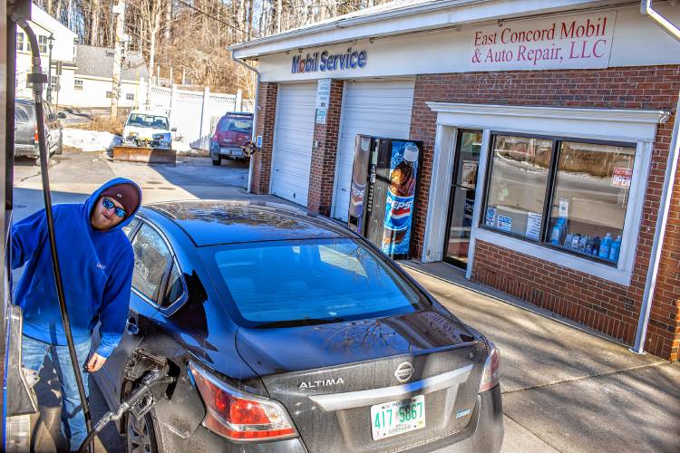 Derek Contarino pumps gas at the full service pump on Tuesday, February 20, 2023. Contarino has been working on and off at the East Concord Mobil and Auto Repair for the last 14 years, helping owner Fadi Sarkis with pumping gas and helping with repairs at the full service station right off of exit 16 in Concord.