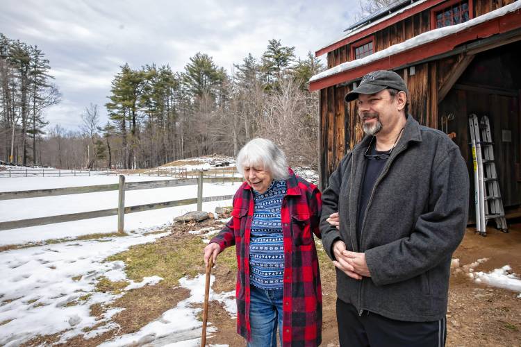 Roy Plisko walks with his mother, Virginia LaPlante outside his mother’s barn at her farm in Canterbury on Wednesday, March 27, 2024. New Hampshire Horse Council’s Board of Directors named LaPlante New Hampshire's 2024 Horse Person of the Year.