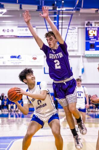 Concord Christian forward Alex Xu (left) gives a pump fake against Groveton forward Isaac Noyes during the second half on Thursday night. Concord Christian won, 61-56, to advance to Monday’s semifinal round.
