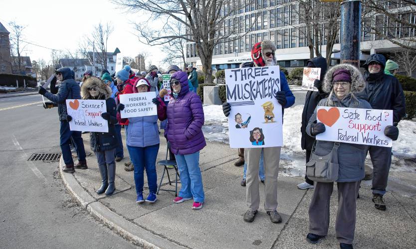 ABOVE: Protesters stand outside the Federal Building on Pleasant Street on Friday morning.