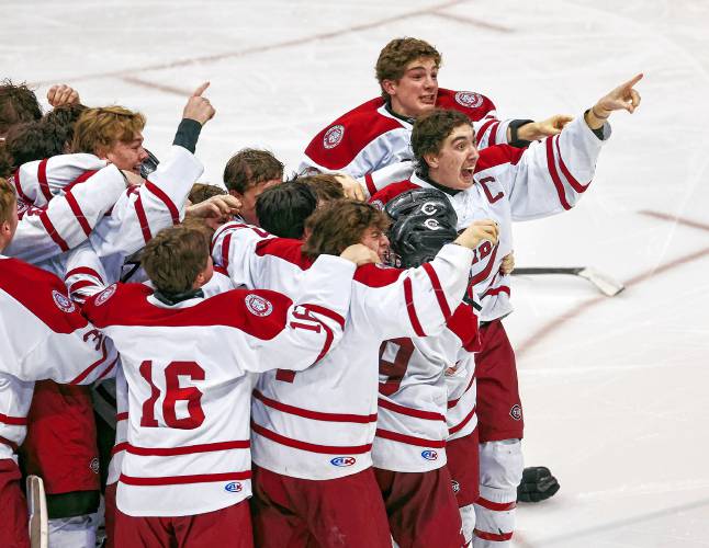 Concord players celebrate after winning the longest championship game in NHIAA hockey history with a 2-1 quadruple overtime victory.