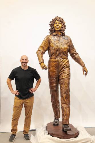 Benjamin Victor with the sculpture he created of Christa McAuliffe in his workspace.