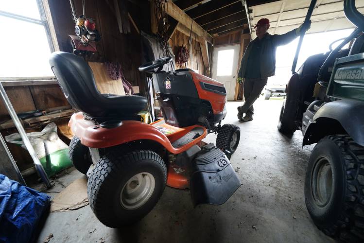 Trailer park owner Ed Smith looks at one of Geoffrey Holt's riding mowers at Stearns Park, Wednesday, Nov. 15, 2023, in Hinsdale, N.H. (AP Photo/Robert F. Bukaty)