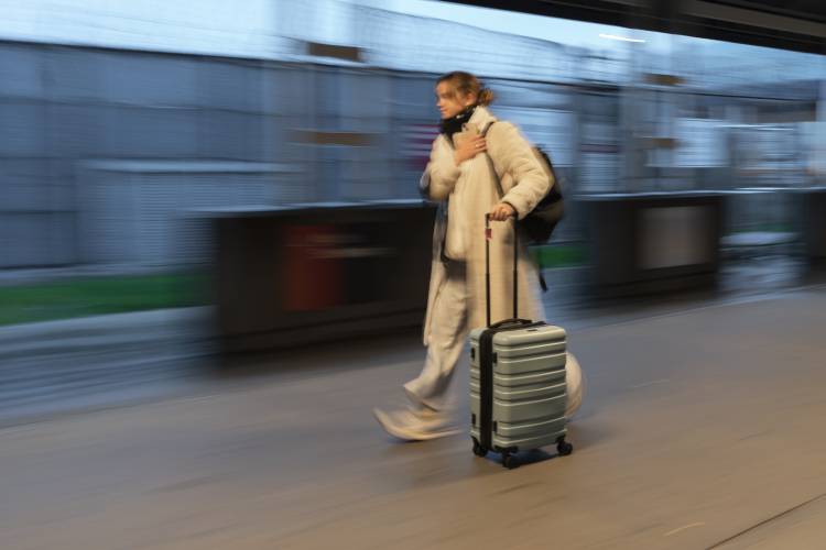A man with his suitcase enters a terminal at LaGuardia Airport in New York, Tuesday, Nov. 21, 2023. (AP Photo/Peter K. Afriyie)