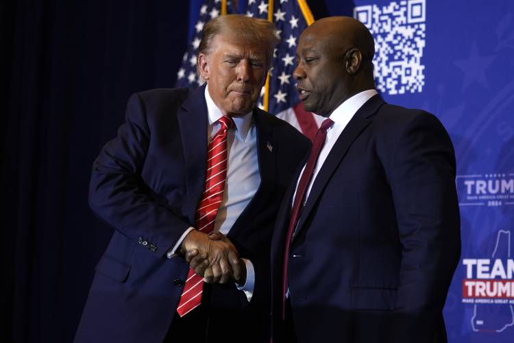 Republican presidential candidate former President Donald Trump shakes hands with Sen. Tim Scott, R-S.C., at a campaign event in Concord, N.H., Friday, Jan. 19, 2024. (AP Photo/Matt Rourke)
