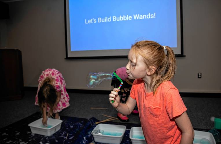 Eleanor Morse, 8, blows bubbles as part of the summer âMad Scienceâ program at the Concord Library auditorium on August 27, 2024.