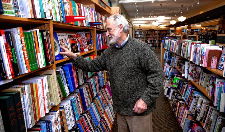 Michael Herrmann of Gibson’s Bookstore looks at the store’s cooking section selections on Wednesday. Hermann won 2024’s New Hampshire Retailer of the Year.