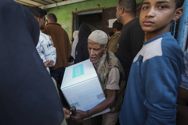 Palestinians receive aid distributed by UNRWA, the U.N. agency helping Palestinian refugees, in Nusairat refugee camp, Gaza, Tuesday, Nov. 5. Palestinians receive aid distributed by UNRWA, the U.N. agency helping Palestinian refugees, in Nusairat refugee camp, Gaza, Tuesday, Nov. 5.