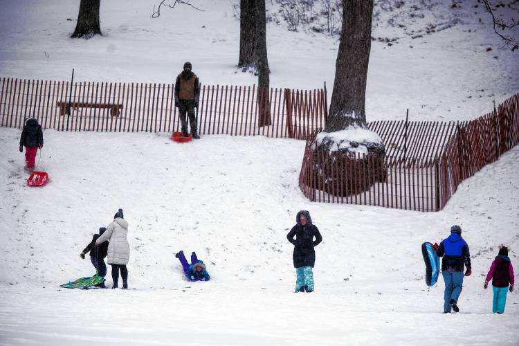 The snow hill at White Park was popular during the Sunday snowstorm for sledders and parents.