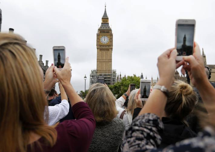 FILE- People record the Big Ben clock at Elizabeth Tower in London, Monday, Aug. 21, 2017. Once again, most Americans will set their clocks forward by one hour this weekend, losing perhaps a bit of sleep but gaining more glorious sunlight in the evenings as the days warm into summer. There's been plenty of debate over the practice but about 70 countries — about 40 percent of those across the globe — currently use what Americans call daylight saving time. (AP Photo/Frank Augstein, File)