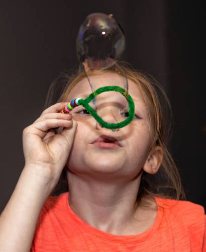 Eleanor Morse, 8, blows bubbles as part of the summer “Mad Science” program at the Concord Library.