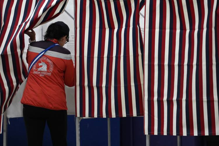 A voter enters a booth to fill out a ballot in a primary election to pick candidates for governor, the U.S. House, and the state Legislature, Tuesday, Sept. 10, 2024, in Nashua, N.H.