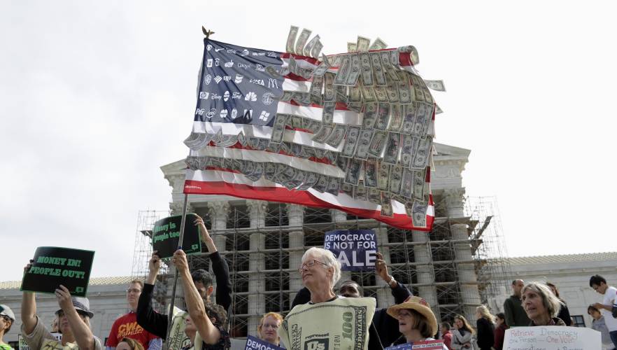 Demonstrators gather outside the Supreme Court in Washington, Tuesday, Oct. 8, 2013, as the court heard arguments on campaign finance.
