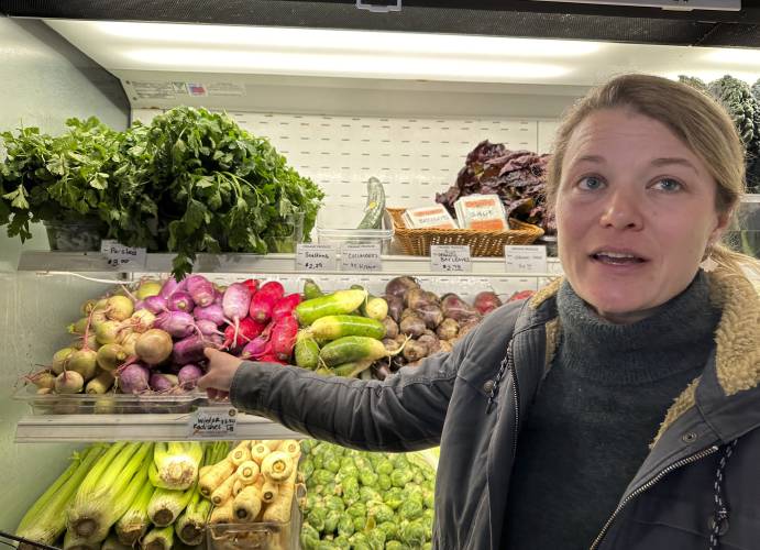 Karin Bellemare, of Bear Roots Farm, points out winter radishes grown at the farm at Roots Farm Market in Middlesex, Vt., on Friday. 