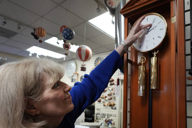 Glenda Marchesoni, owner of Heritage House Clocks, adjusts a German clock at her shop Tuesday, March 5, 2024, in Farmers Branch, Texas. Once again, most Americans will set their clocks forward by one hour this weekend, losing perhaps a bit of sleep but gaining more glorious sunlight in the evenings as the days warm into summer. (AP Photo/LM Otero)