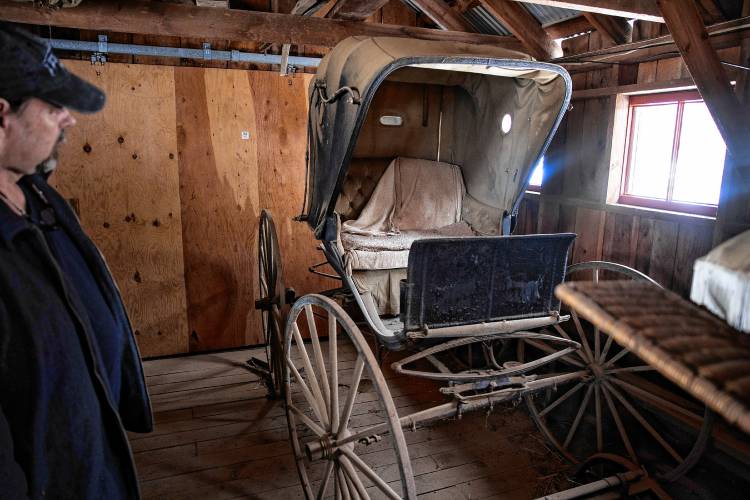 Roy Plisko looks over one of the horse carriages in his motherâs barn at her farm in Canterbury on Wednesday, March 27, 2024. New Hampshire Horse Councilâs Board of Directors named his mother, Virginia LaPlante, New Hampshire's 2024 Horse Person of the Year.