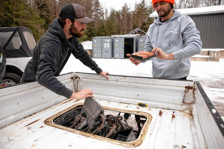 Stan Nelson (right), who co-owns Granite State Imports, checks the air filter in the engine compartment up of Subaru mini dump truck at their location on Sugar Hill Road on Friday, January 31, 2025. Nelson and co-owner Dylan Beckerman (left), import the vehicles from Japan and they work with Village Street Garage in Penacook to get them to pass inspection and then the pair do modifications for their clients.