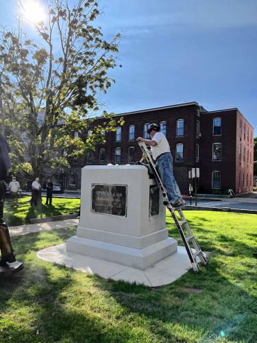 Workers get ready to put the statue of Christa McAuliffe into place at the State House before the unveiling.