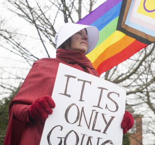 Jody Doele, dressed as a handmaid from the book and television series “The Handmaid's Tale,” protests during a “Hands Off!” rally at Main Street Park in Easthampton, Mass. Jody Doele, dressed as a handmaid from the book and television series “The Handmaid's Tale,” protests during a “Hands Off!” rally at Main Street Park in Easthampton, Mass.