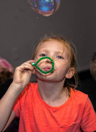 Eleanor Morse, 8, blows bubbles as part of the summer âMad Scienceâ program at the Concord Library auditorium on August 27, 2024. 