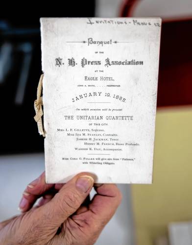  Volunteer Ginny Babczak holds up a 1855 invitation to the New Hampshire Press Association at the Eagle Hotel as she prepares to scan it in for the digital archive for the library. Babczak is a former librarian who comes in to scan materials.