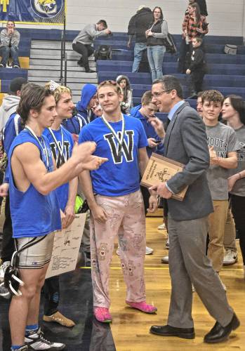 From left, Winnisquam wrestlers Ryan Cormier, Aemon Gauthier and David Jean congratulate head coach Tom Osmer (right) after he was named the Division III Coach of the Year. Osmer was voted for the award by his peers after leading the Bears to second in Division III on Saturday.