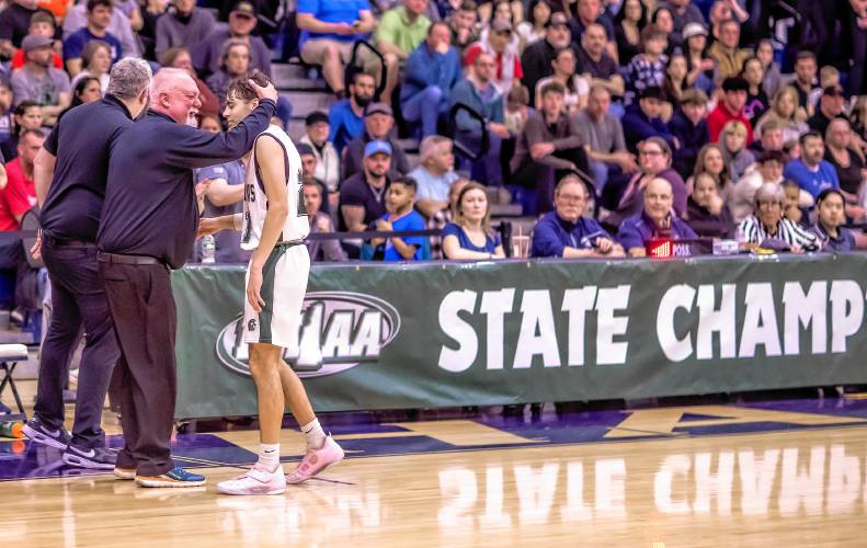 Pembroke guard Andrew Fitzgerald gets a hug from head coach Mike Donnell after he was pulled from the championship game in the waning moments as the Spartans won the D-II boys’ basketball title over Sanborn on Sunday in Durham.