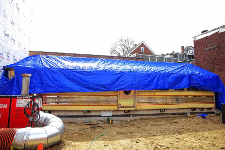 The construction of the Friendly Toast and Arts Alley in downtown Concord is taking shape. The renovated historic diner in back of the alley is stilled wrapped after its move late last year.