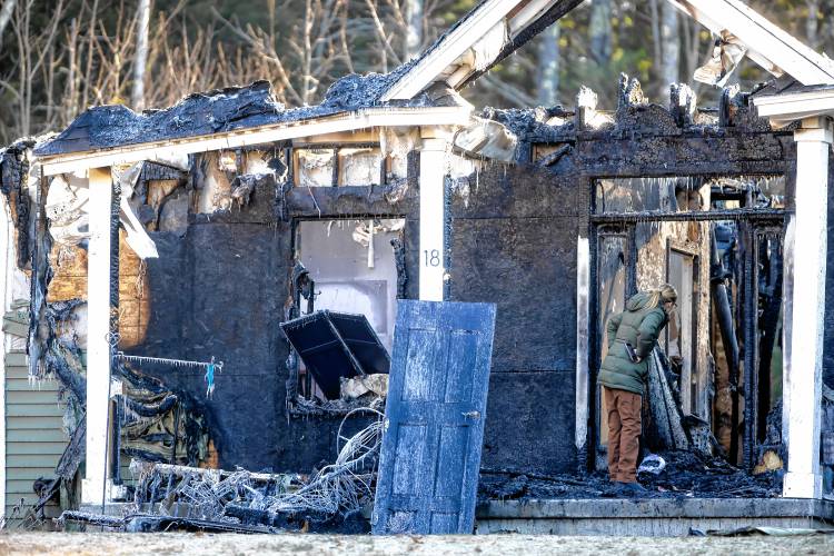 Megan McLean inspects the damage of her parentâs home on Granite Valley in Contoocook on Friday, November 30, 2023.
