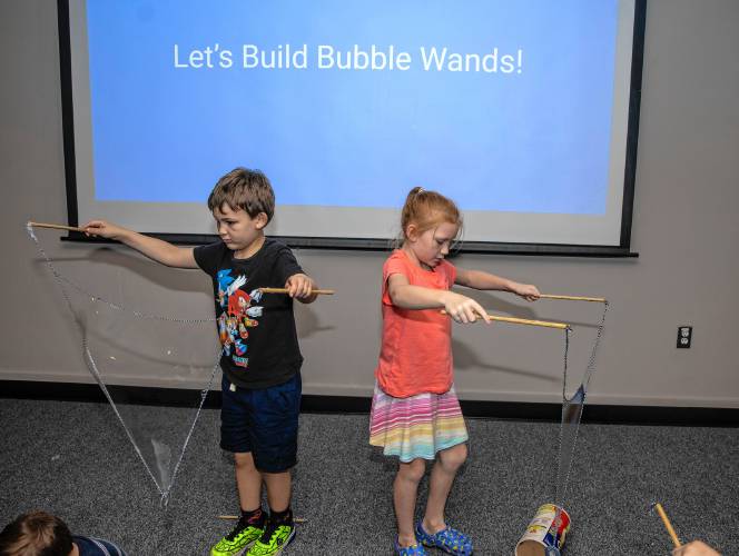 Michael Poifier and Eleanor Morse create large bubbles at the âMad Scienceâ summer program at Concord Library on August 27, 2024.