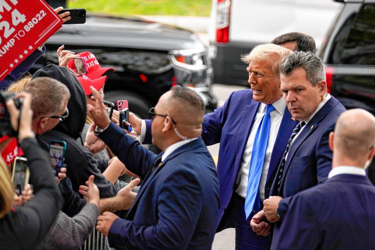 Republican presidential candidate former President Donald Trump greets supporters as he arrives to sign papers to be on the 2024 Republican presidential primary ballot at the New Hampshire Statehouse, Monday, Oct. 23, 2023, in Concord, N.H. (AP Photo/Charles Krupa)
