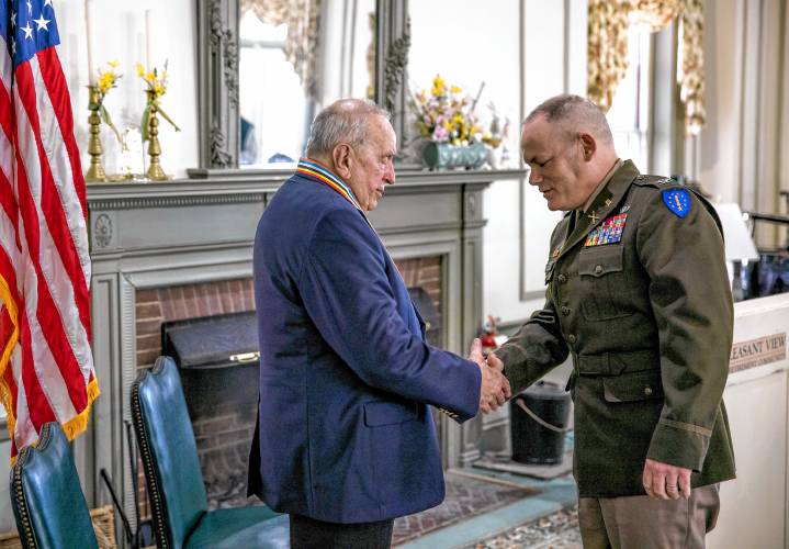 Col. Erik Fessenden, director of joint staff of the New Hampshire National Guard, shakes Jerry Lavigne’s hand after he was awarded a medal as an Ambassador of Peace at the Pleasant View ceremony on Saturday afternoon, February 24, 2024.