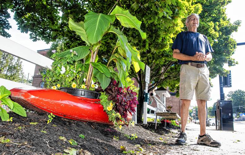 Glenn Morill stands along Central Street in Franklin, where kayaks adorn the street repurposed as flower beds. Morrill leads a team of volunteers behind the kayak flowerbeds each year.