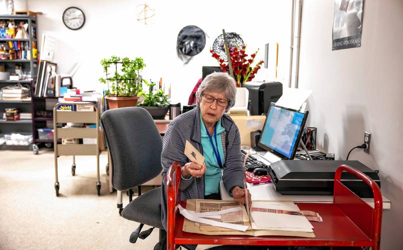 Concord Library volunteer Ginny Babczak looks over documents as she prepares to scan in materials for the digital archive for the library. Babczak is a former librarian who comes in to scan materials.