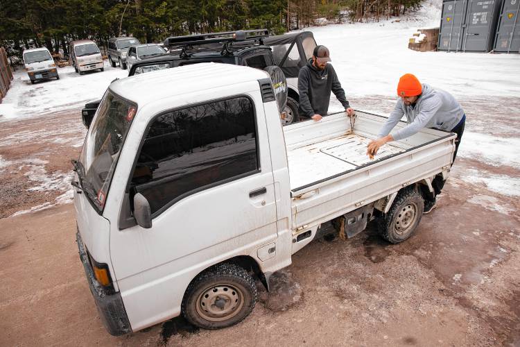 Stan Nelson (right), who co-owns Granite State Imports in Hopkinton, opens up the engine compartment up of Subaru mini dump truck at their location on Sugar Hill Road on Friday, January 31, 2025. Nelson and co-owner Dylan Beckerman (left), import the vehicles from Japan and they work with Village Street Garage in Penacook to get them to pass inspection and then the pair do modifications for their clients.