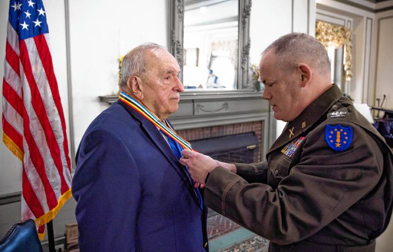 Col. Erik Fessenden, director of joint staff of the New Hampshire National Guard, places the medal from South Korea honoring Jerry Lavigne at the Pleasant View ceremony on Saturday afternoon, February 24.