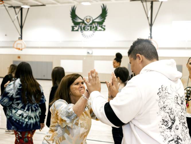 Allenstown principal Shannon Kruger greets student Devonte Riveria at the school gymnasium of the Allenstown Community School on Thursday.