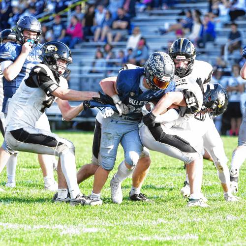 Merrimack Valley running back Reece Clermont (21) plows through several Kennett tacklers during MV’s homecoming football on Saturday. Clermont scored four rushing touchdowns to lead the Pride to a 28-7 victory.