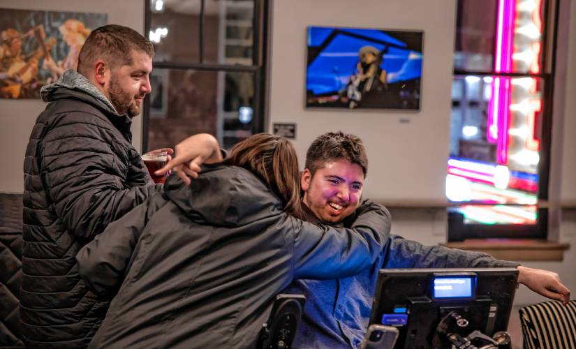Samuel Habib gets a hug from Sammie Binning before the premiere of his latest documentary, “The Ride Ahead,” at the Bank of NH Stage on Monday. Her husband, Kirk (left), was Samuel’s direct support person for years and is featured in the film.