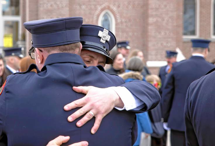 Firefighter Sam Cahan gets a hug from a fellow Concord firefighter after the service for CJ Girard at Christ the King Catholic Church on Thursday, March 13, 2025. Cahan gave the eulogy for Girard during the service.