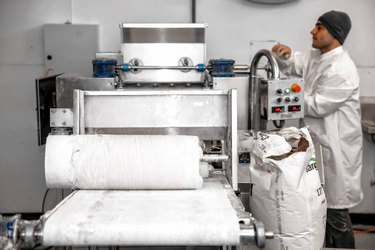 Aissa Sweets owner, Amhad Aissa, operates the roller that flattens the paper-thin dough to make the custom Baklava at his production facility on Hall Street in Concord.