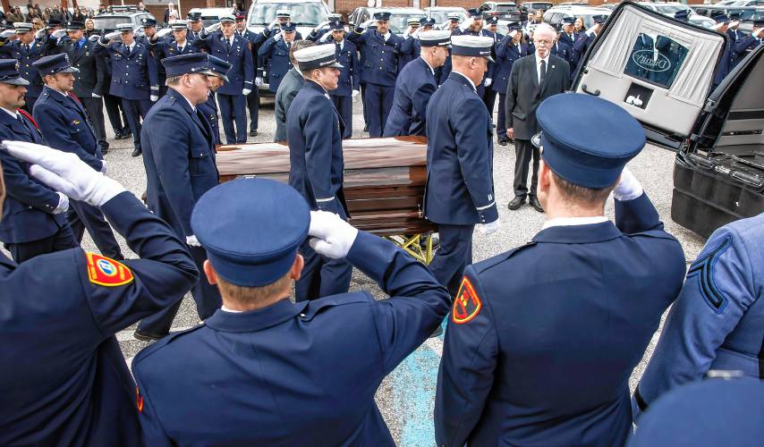 Firefighters from around the state salute as the casket is loaded into a hearse after the funeral service for Concord firefighter CJ Girard at Christ the King Catholic Church on Thursday.