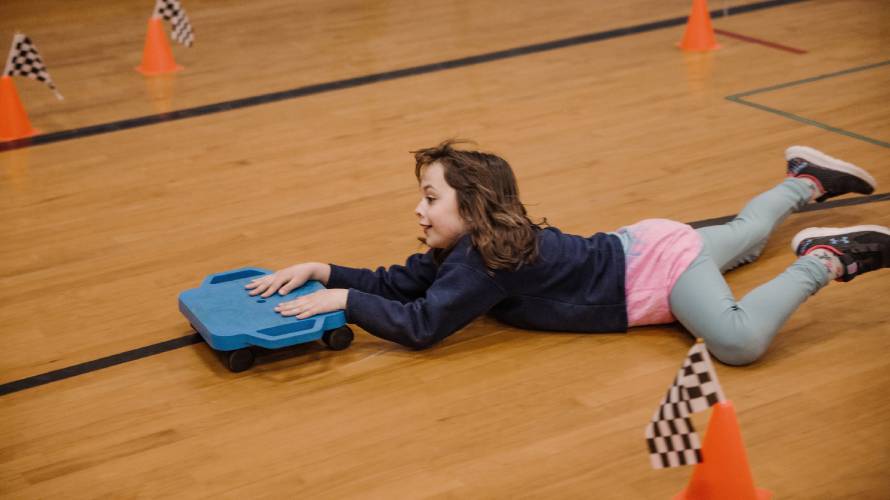 Bailey Flood, 8, races Penacook Elementary School assistant prinicipal Zach Stephenson during a Mario cart race in the school gymnasium on Thursday, March 27, 2025. The Mario Brothers-themed Escape Room included the whole school where students and their families solved mysteries in classrooms and had pizza as well.