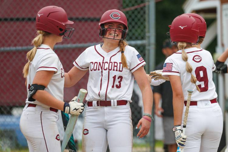 Maggie Taylor (13) celebrates at home plate with her teammates after her 3-run homer on Monday in a Division I softball quarterfinal at Goffstown High School. Taylor’s home run in the top of the fifth inning gave Concord softball a 5-1 lead. The Tide scored five runs in the inning and No. 12 Concord upset No. 4 Goffstown, 7-1, to reach the final four for the 15th time in the last 20 seasons.